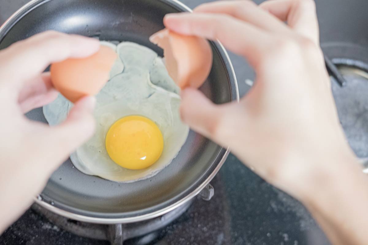 Infographic comparing silicone, stainless steel, and electric egg poachers by ease of use, durability, and egg quality