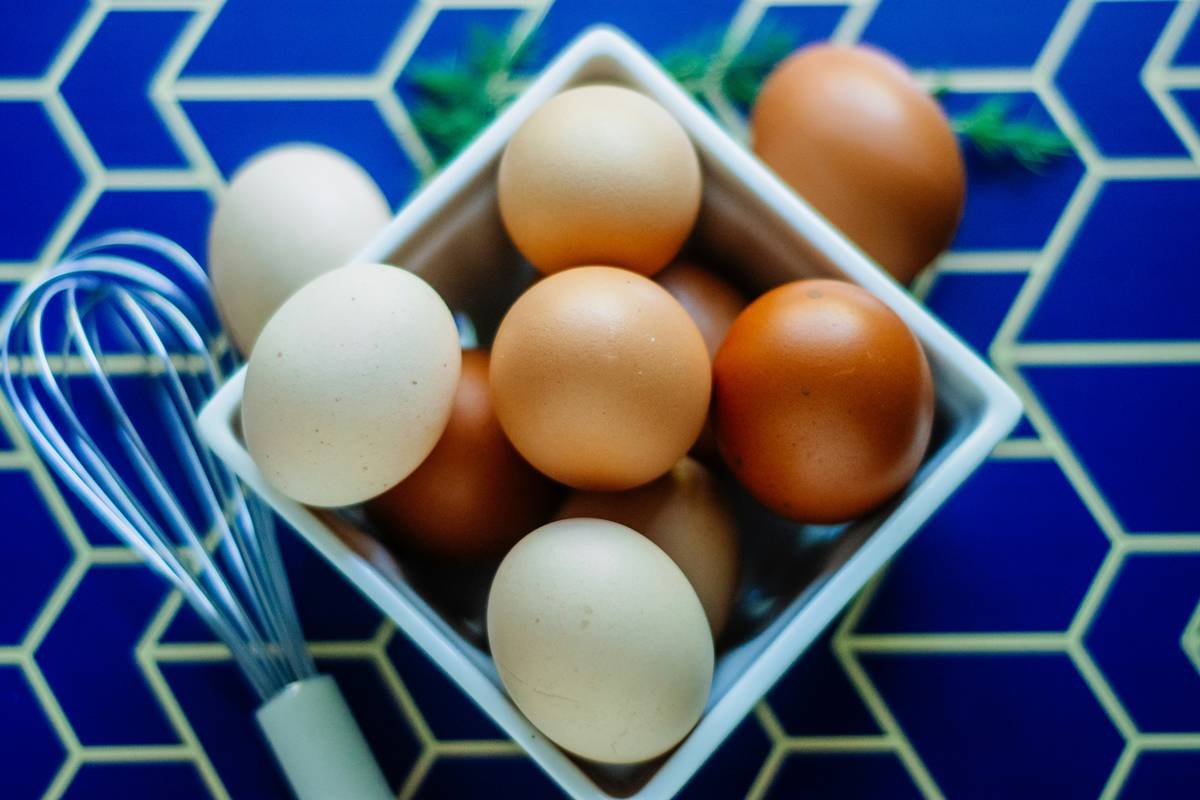 Chef using a precision tool for breaking eggs on a marble countertop