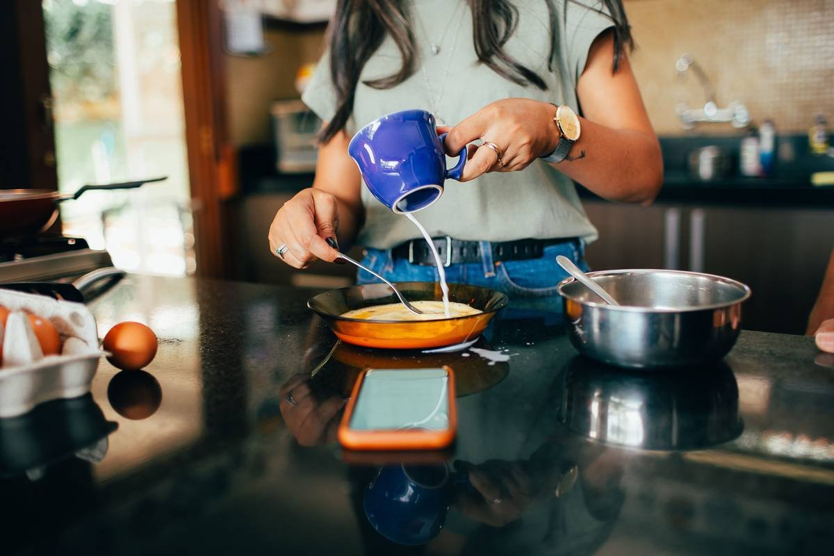 how to use egg poacher with stainless steel cups filled with water and eggs in a saucepan